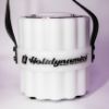 Plastic bluetooth speaker labeled with Holidynamics logo on the middle band displayed unlit and forward facing on white background at close range