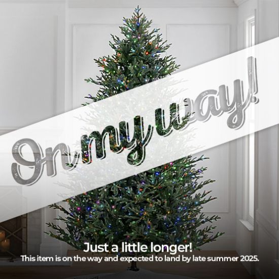 9' Full Fraser Pine displayed in lifestyle shot of living room, lit multi-color, graphic banner across the image with text saying "On my way!". Caption under banner says "Just a little longer! This item is on the way and expected to land by late summer 2025."