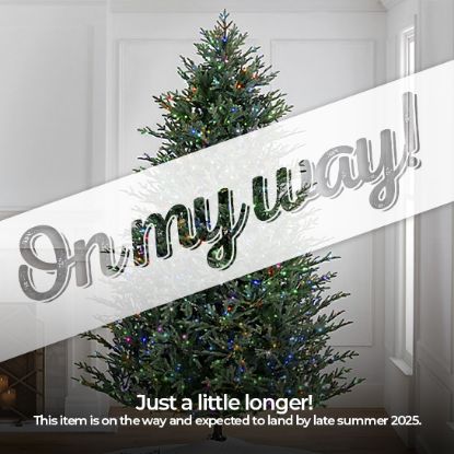 10' Full Fraser Pine displayed in lifestyle shot of living room, lit multi-color, graphic banner across the image with text saying "On my way!". Caption under banner says "Just a little longer! This item is on the way and expected to land by late summer 2025."