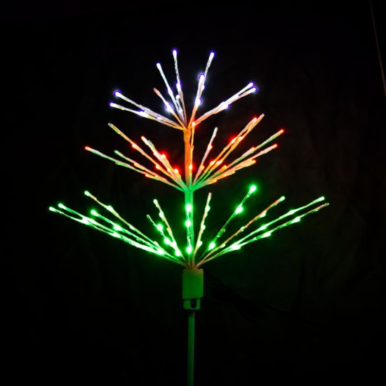Paramount Spritzer yard stake decoration illuminated in pure white, red, and green against a black background.