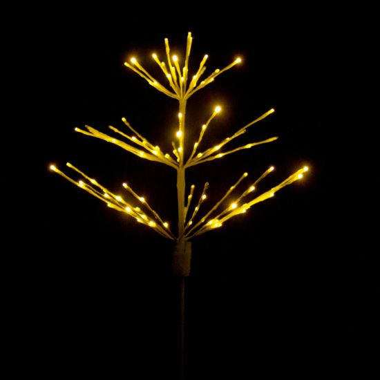 Paramount Spritzer yard stake decoration illuminated in warm white against a black background.