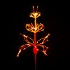 Paramount Spritzer yard stake decoration, sculpted into a flower and illuminated in blue against a black background.