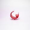 A small, plastic cellphone holder with a red interior and clear exterior, featuring the Holidynamics logo on the front. The holder is shaped like a curved “C” and sits on a white background.
