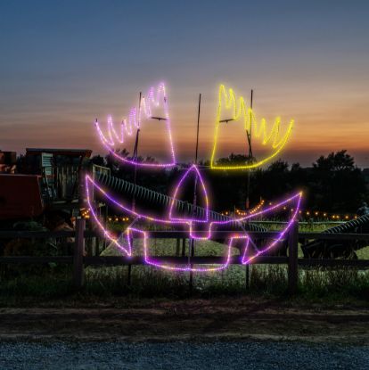 Lady Pumpkin Face Jack-O-Lantern lit in multiple colors at Skinny Bones Pumpkin patch