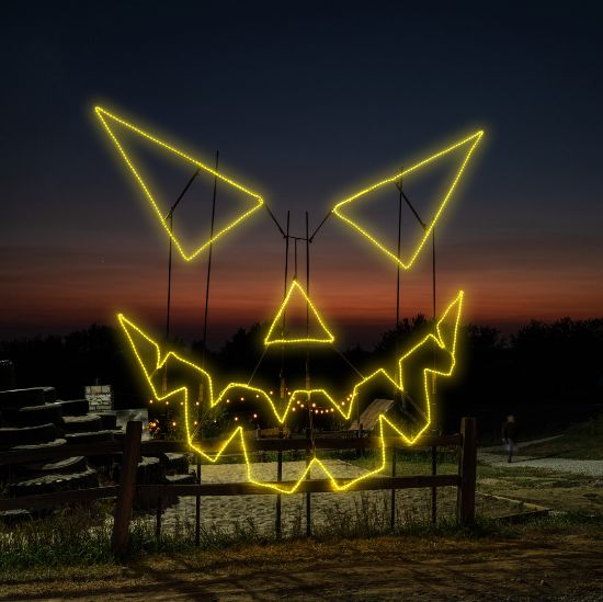 Evil Pumpkin Face Jack-O-Lantern lit in yellow at Skinny Bones Pumpkin patch